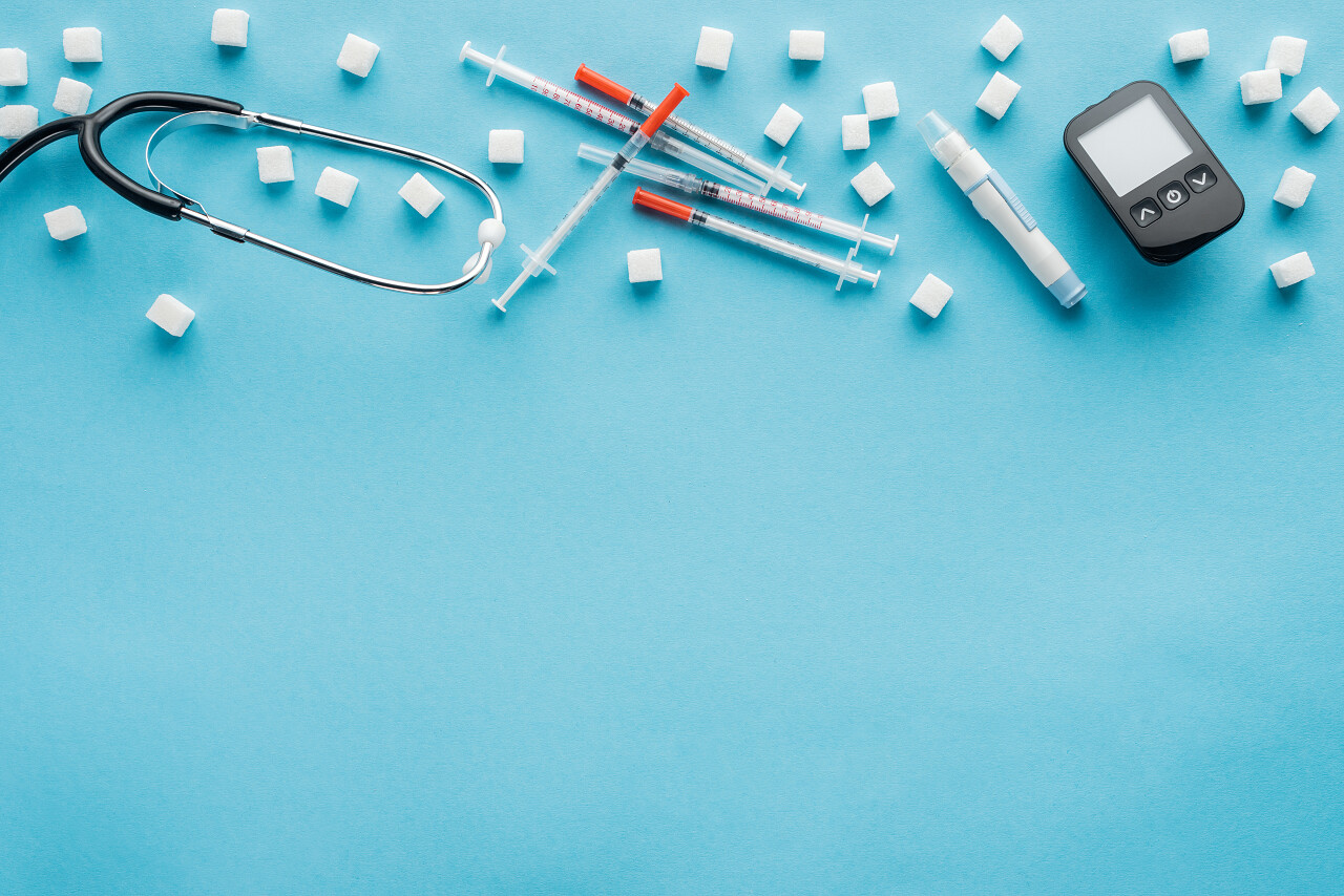 蓝色背景上糖尿病医疗设备的顶部视图