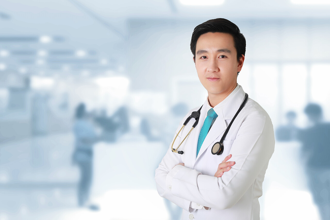 医生摆臂交叉医务人员在模糊的背景下工作.