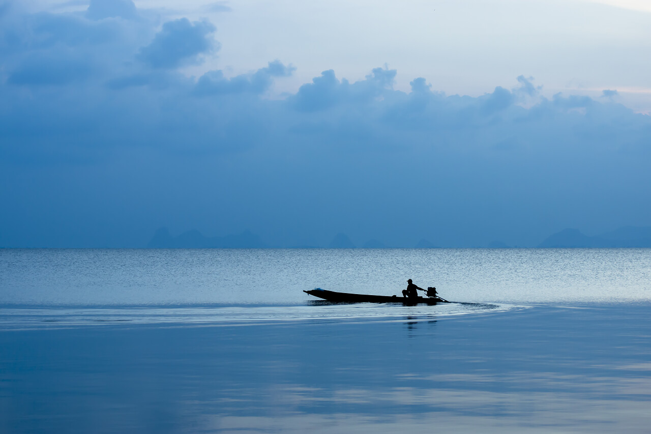 蓝色小时在蓝色小时的最小的渔船剪影在湖