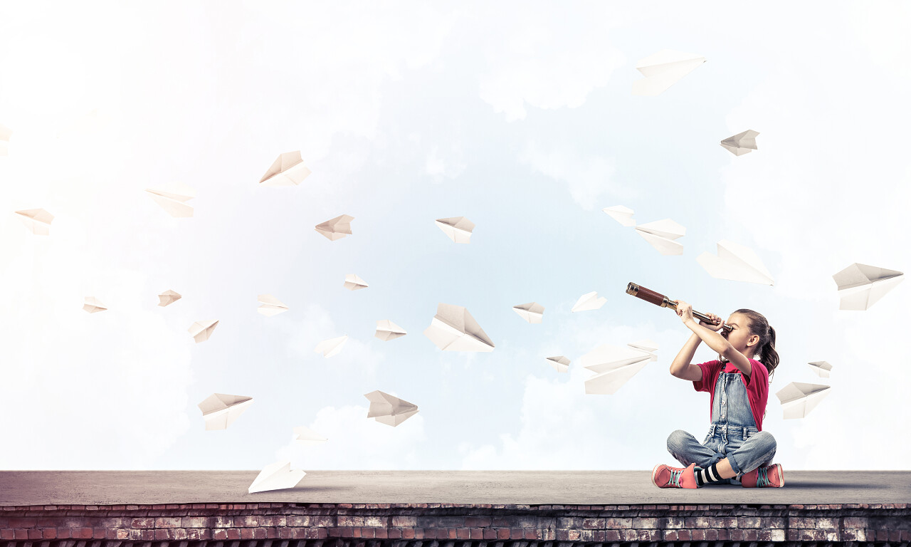 坐在屋顶的小女孩用望远镜看风景