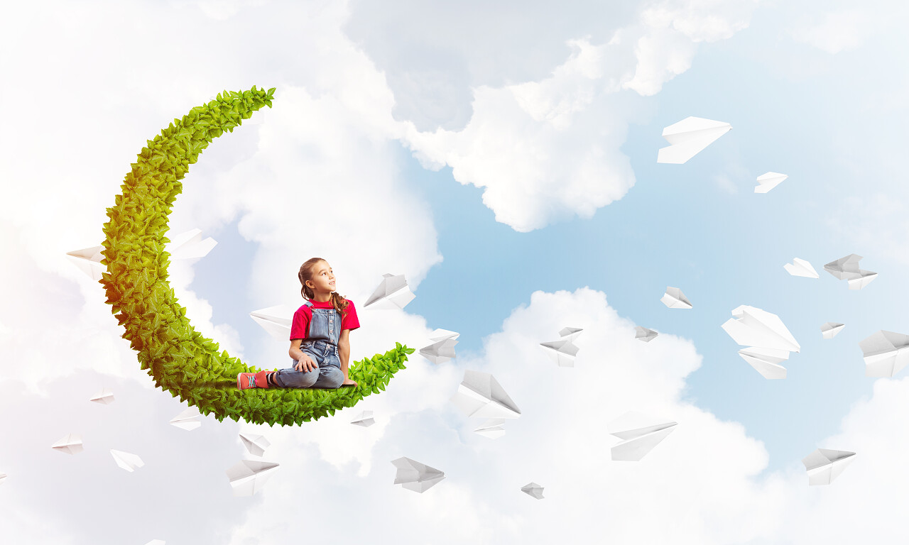 可爱的孩子女孩坐在月亮和纸飞机飞来飞去