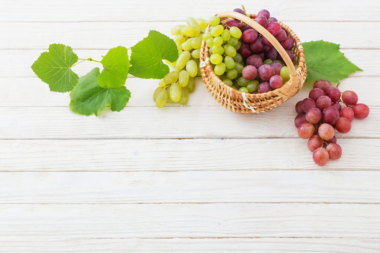 粉红色和绿色的葡萄在木质背景下