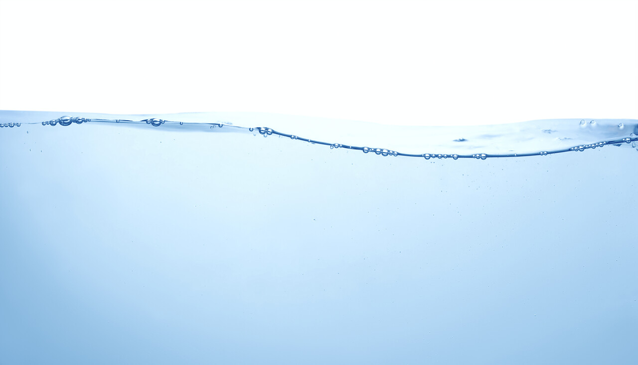 清洁的蓝色水与气泡和溅在白色背景上