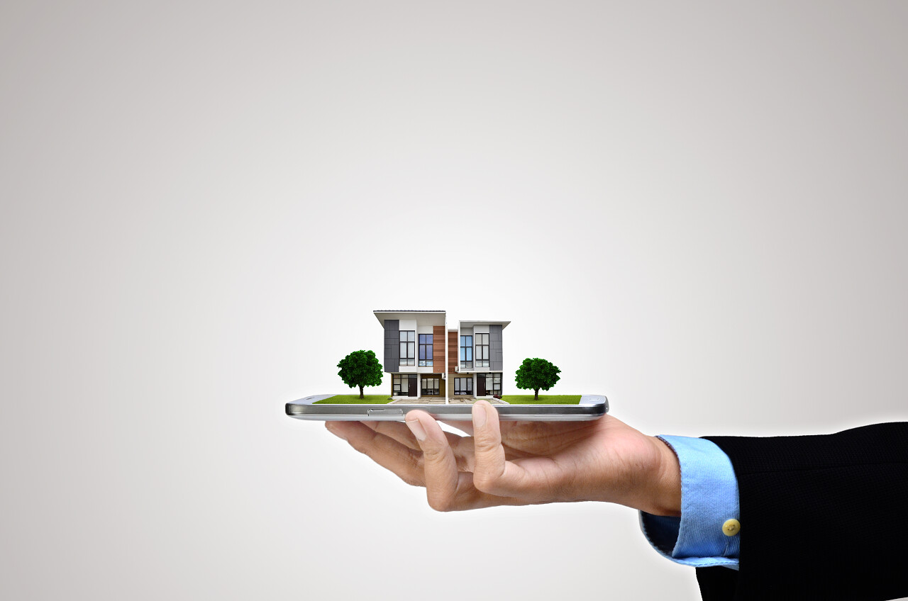 在商人的智能手机上的房子模型