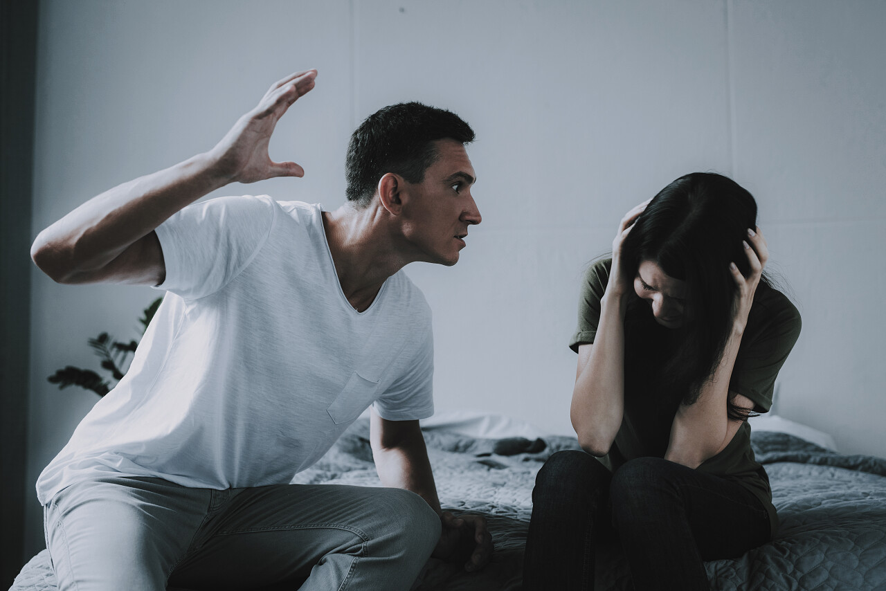 女人和男人在家里坐在床上打架家庭夫妻矛盾
