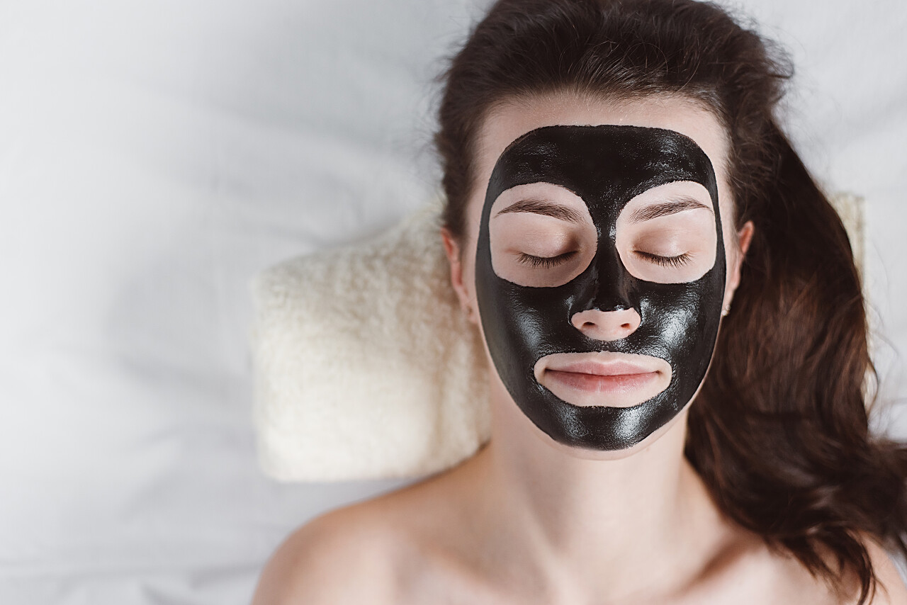 在她的脸上扶着黑色面膜放松补水