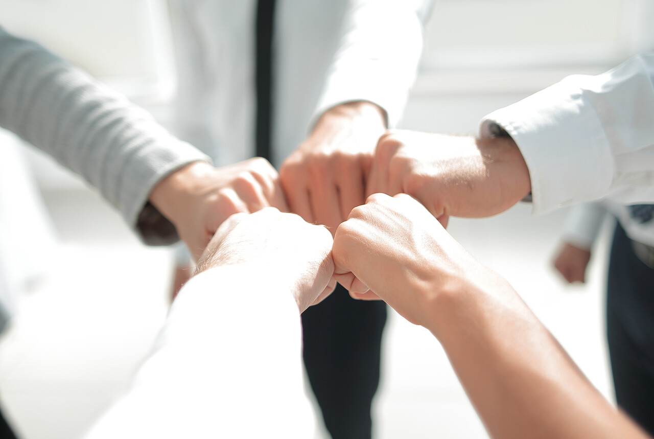 一群年轻人碰拳加油拳头团队加油团结拳头团结手势激励