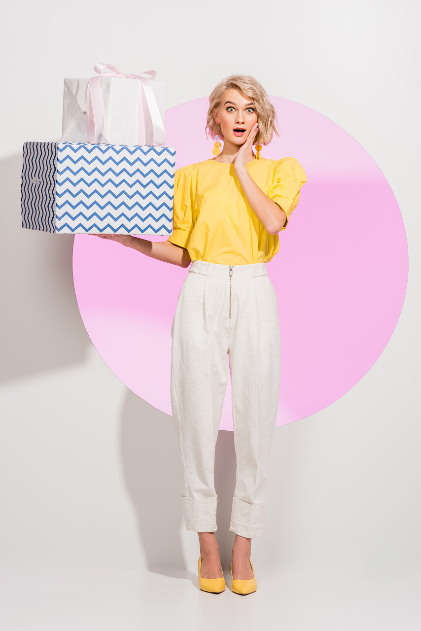 时尚的女孩拿着白色礼品盒震惊