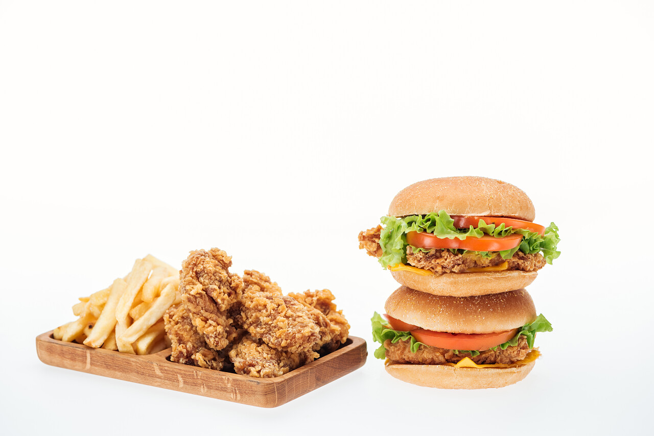 香脆的鸡块鸡肉汉堡和炸薯条隔离在白色