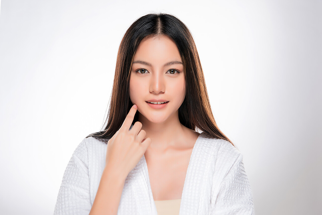 年轻美丽的亚洲女人有着干净新鲜的皮肤.美女脸蛋的护理面部治疗化妆品