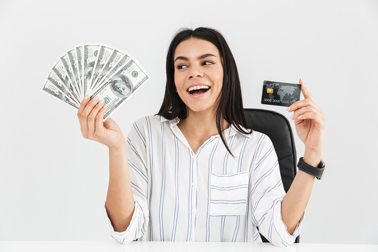 女子拿着信用卡和纸币