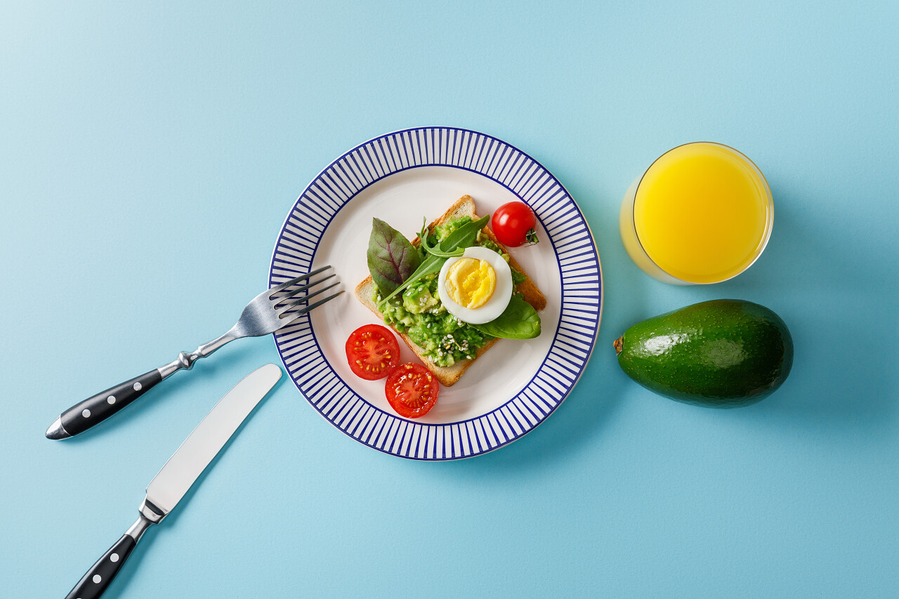 在蓝色背景上用瓜卡莫莱鳄梨和橙汁烤面包的顶视图