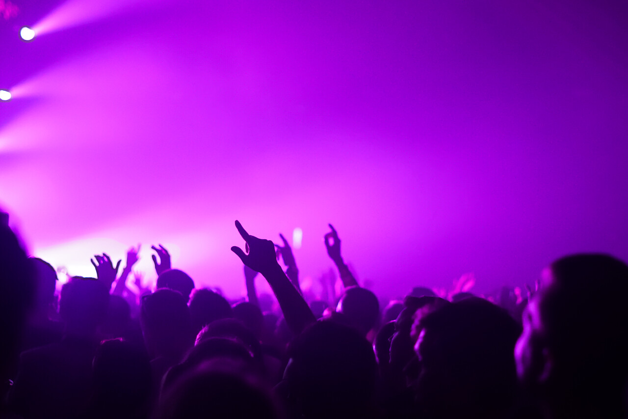 在明亮的舞台灯光前音乐会人群的轮廓