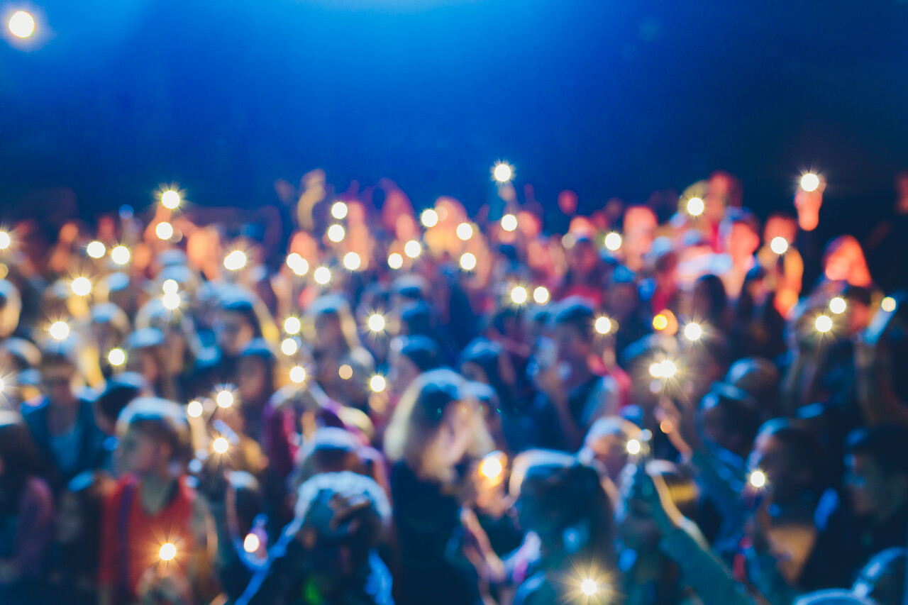 在街头音乐节目中举手投足的人在手机上拍了一个视频背景模糊不清