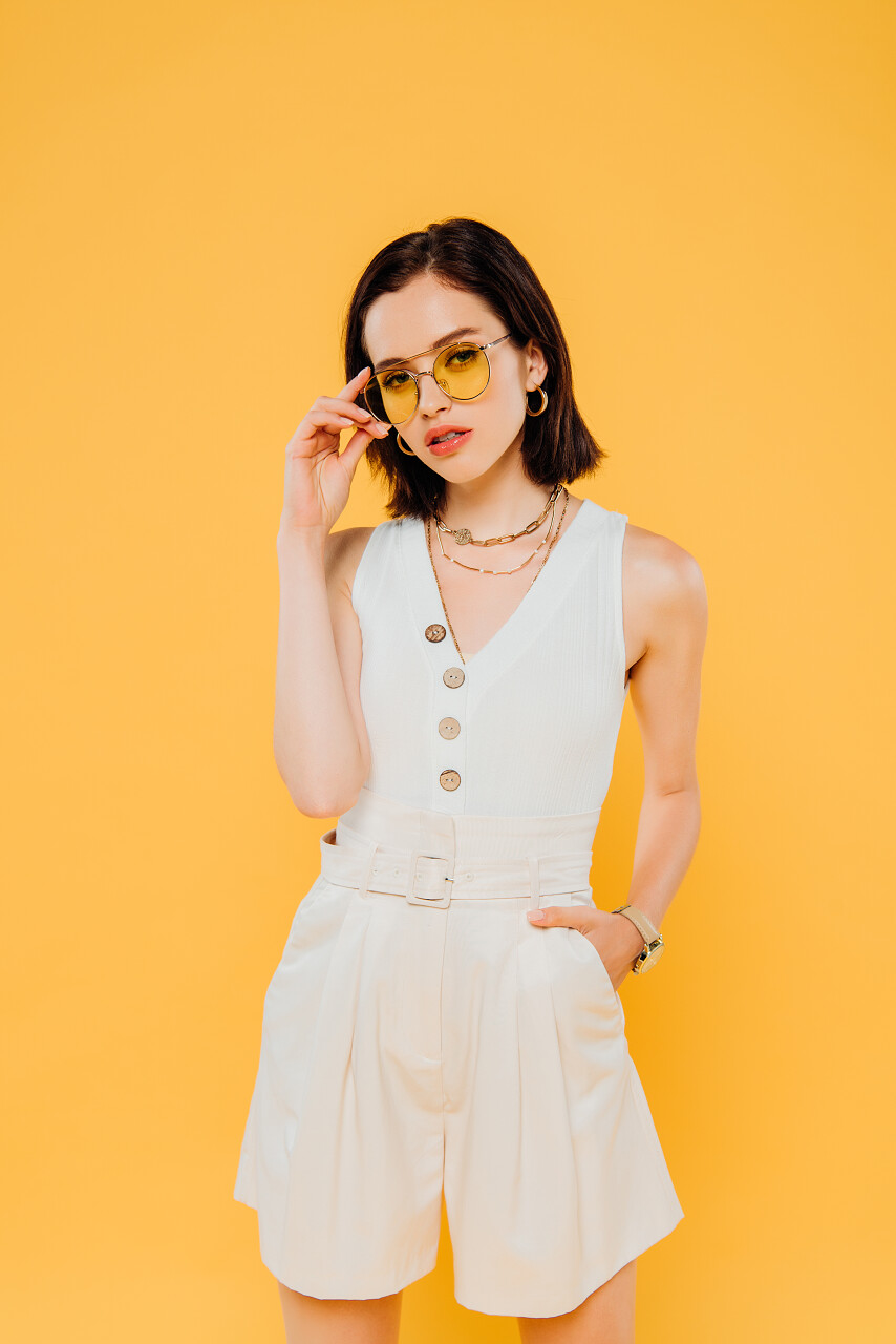 时尚女人在太阳镜摆姿势手在口袋里隔离在黄色背景美女三七女生节37女生节三八妇女节38妇女节