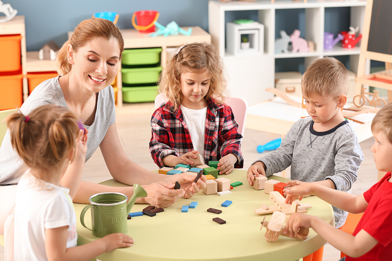 儿童保健幼儿园老师与可爱的小孩在幼儿园