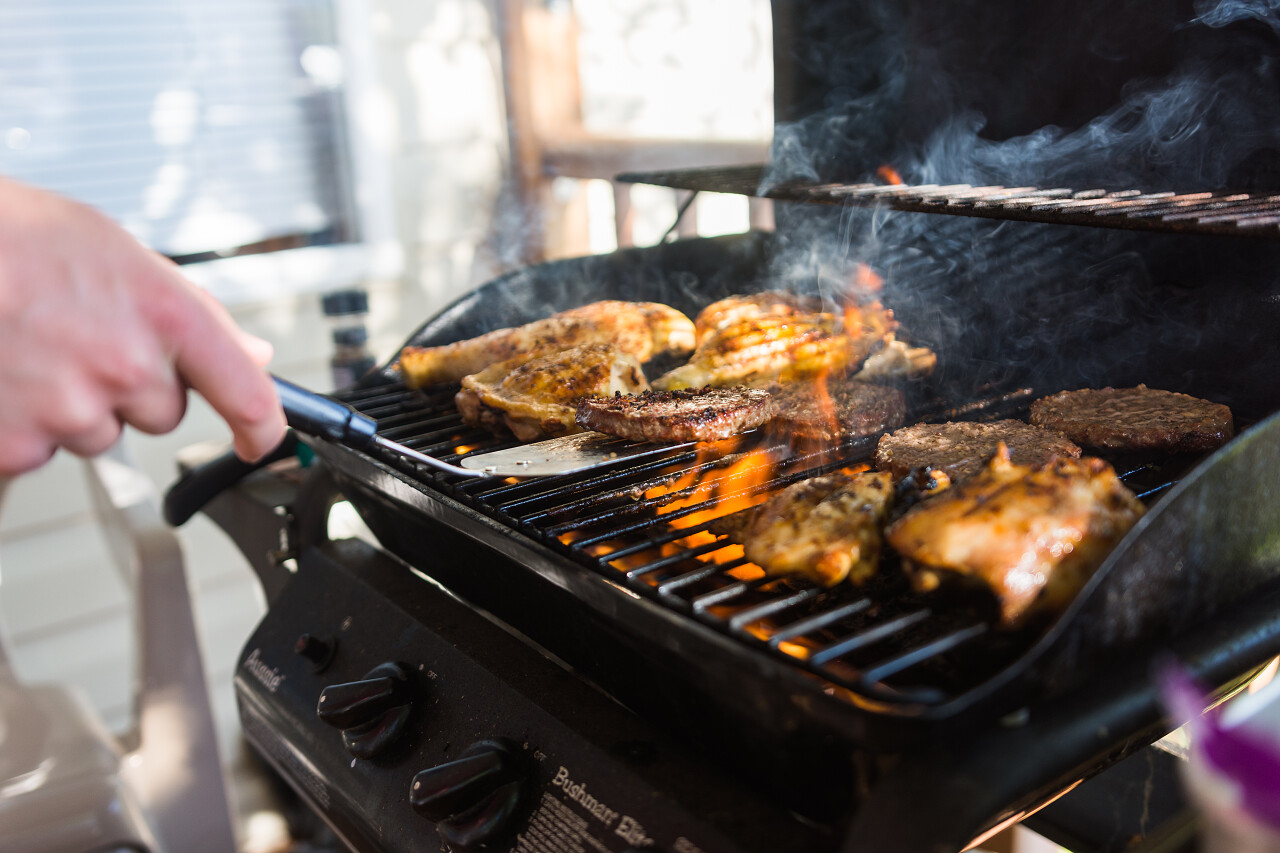 户外煤气炉上烹调的鸡肉和汉堡包