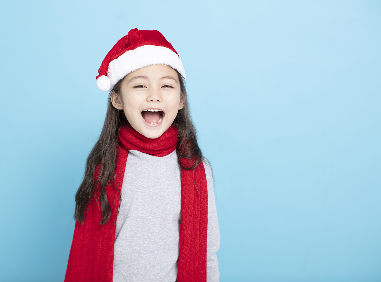 快乐的小女孩在圣诞老人帽子微笑的小女孩