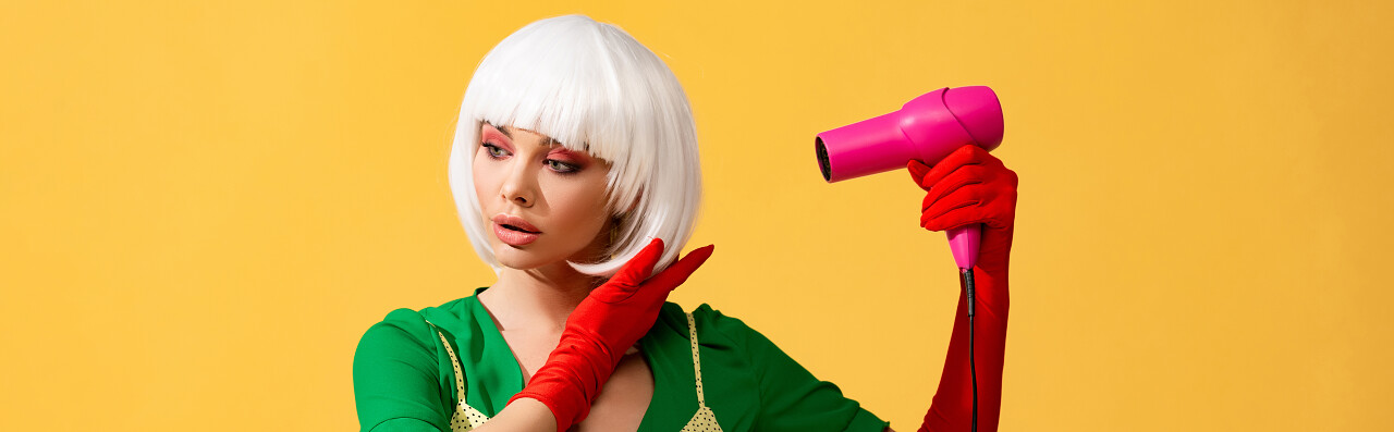 白色假发流行女孩使用粉红色吹风机