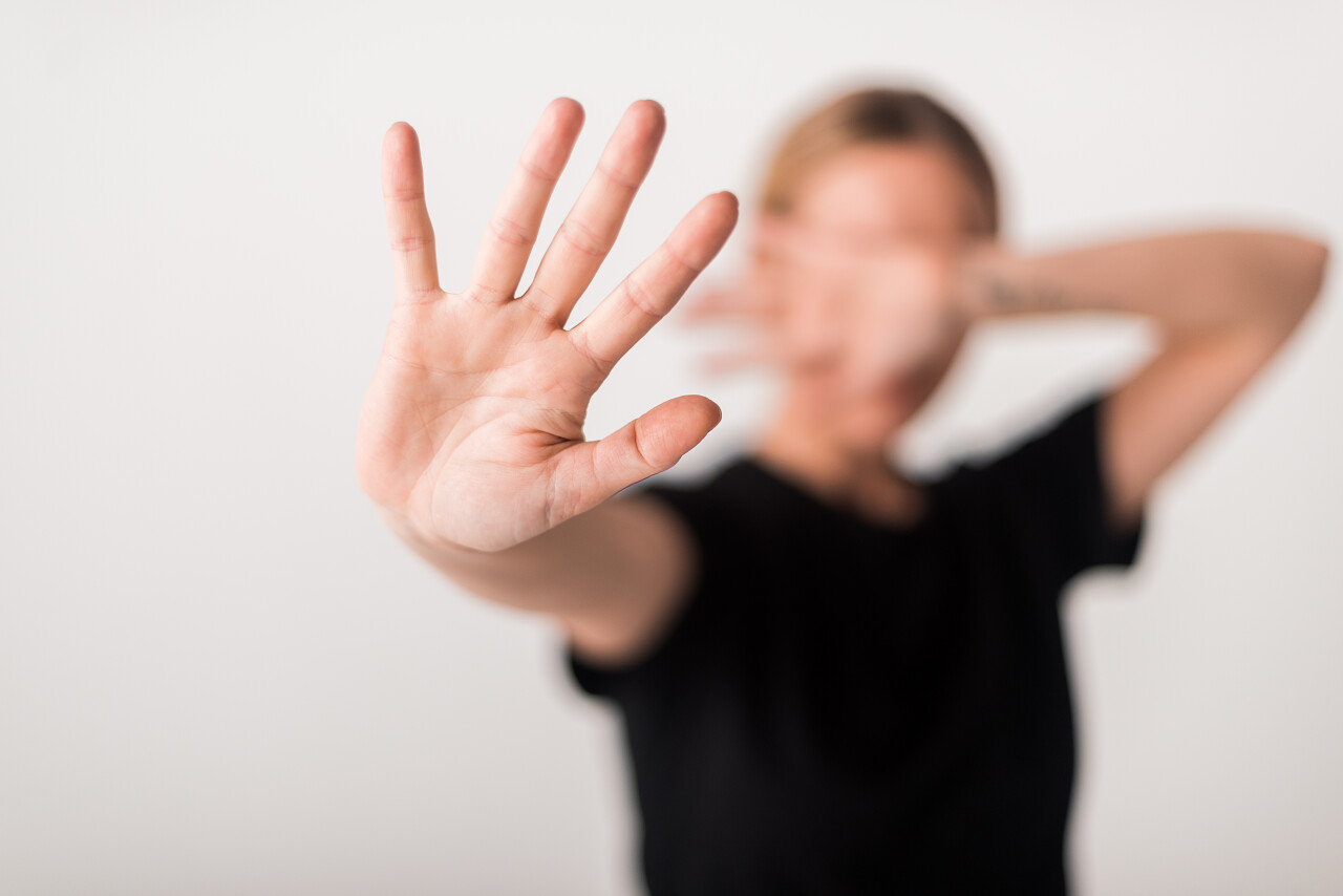 在白色上孤立地显示停止姿势的妇女的选择性焦点