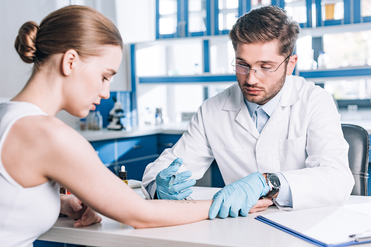 临床医生在妇女身边有选择性地将注射器放在过敏者的焦点上医生打针注射