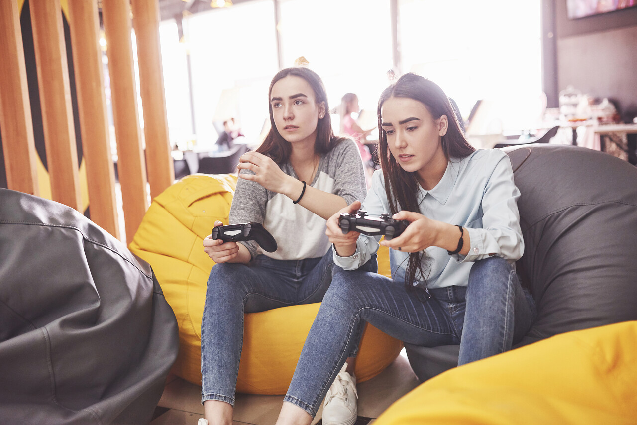 姐妹俩在控制台上玩耍女孩子们手握操纵杆