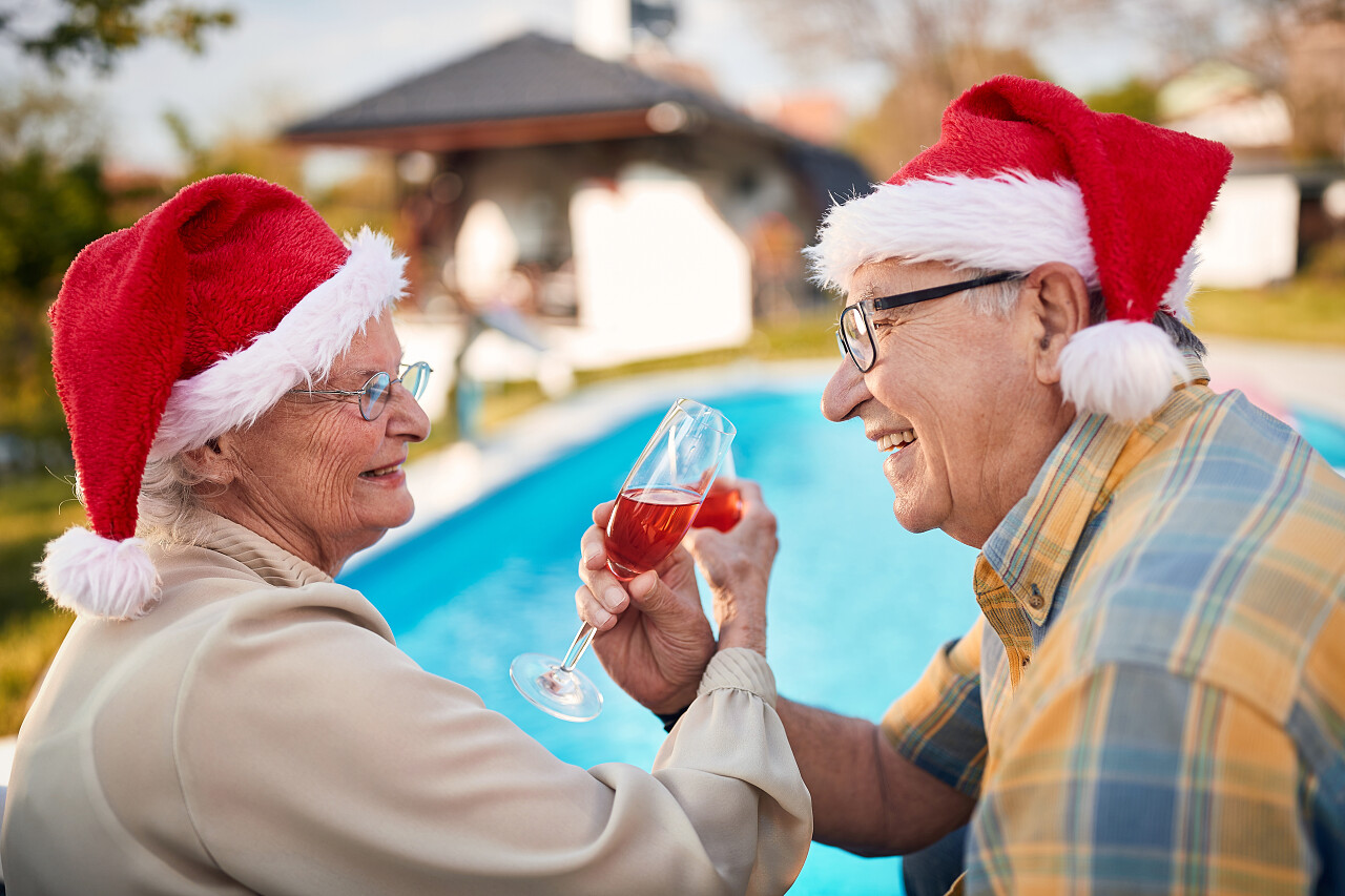 圣诞佳节快乐的老人和戴着圣诞礼帽的女人在一起微笑的老人