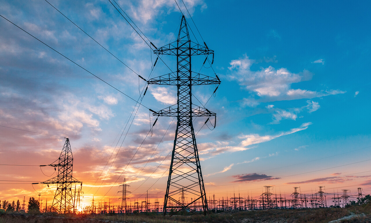 高压电线的后面是美丽的云彩落日的天空