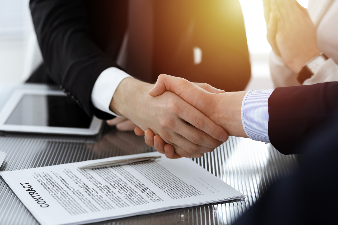 在阳光灿烂的现代办公室里商人们在签约后握手签约成功签约成功合作团结握手企业团结团结人物合作平台商务人士合作握手