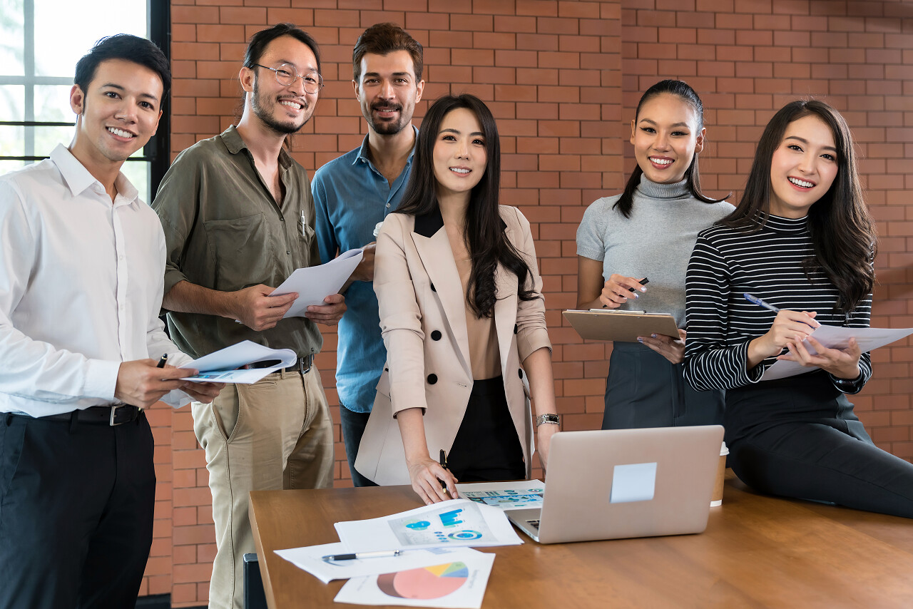 展示了一群不同种族的公司同事在会议室为创办新业务而微笑的形象