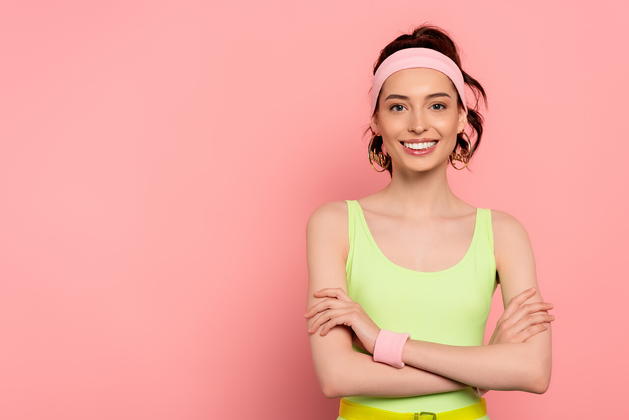 快乐的年轻女子头戴头巾交叉着双臂面带微笑地站在粉色上背景下美女三七女生节37女生节三八妇女节38妇女节