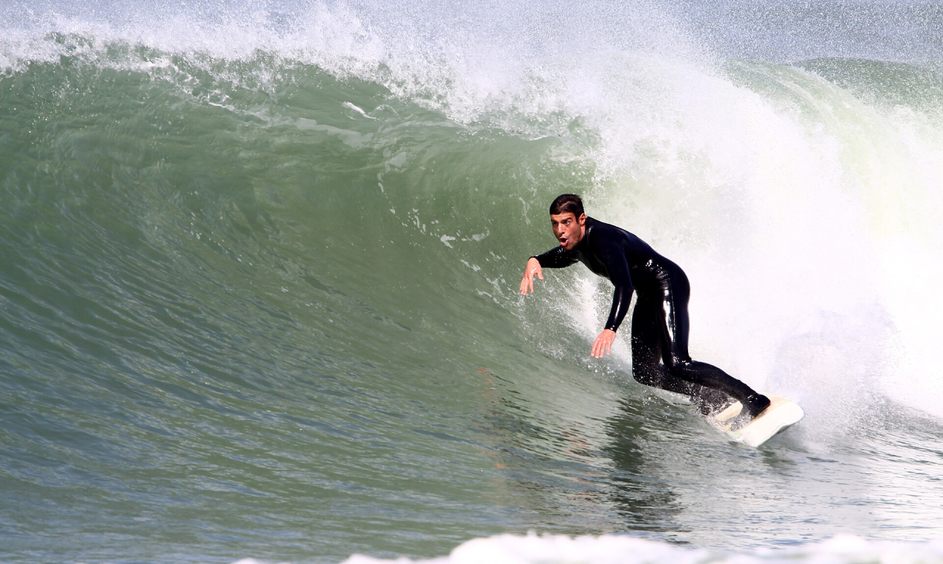 一个正在海上冲浪的年轻男性冲浪浪潮