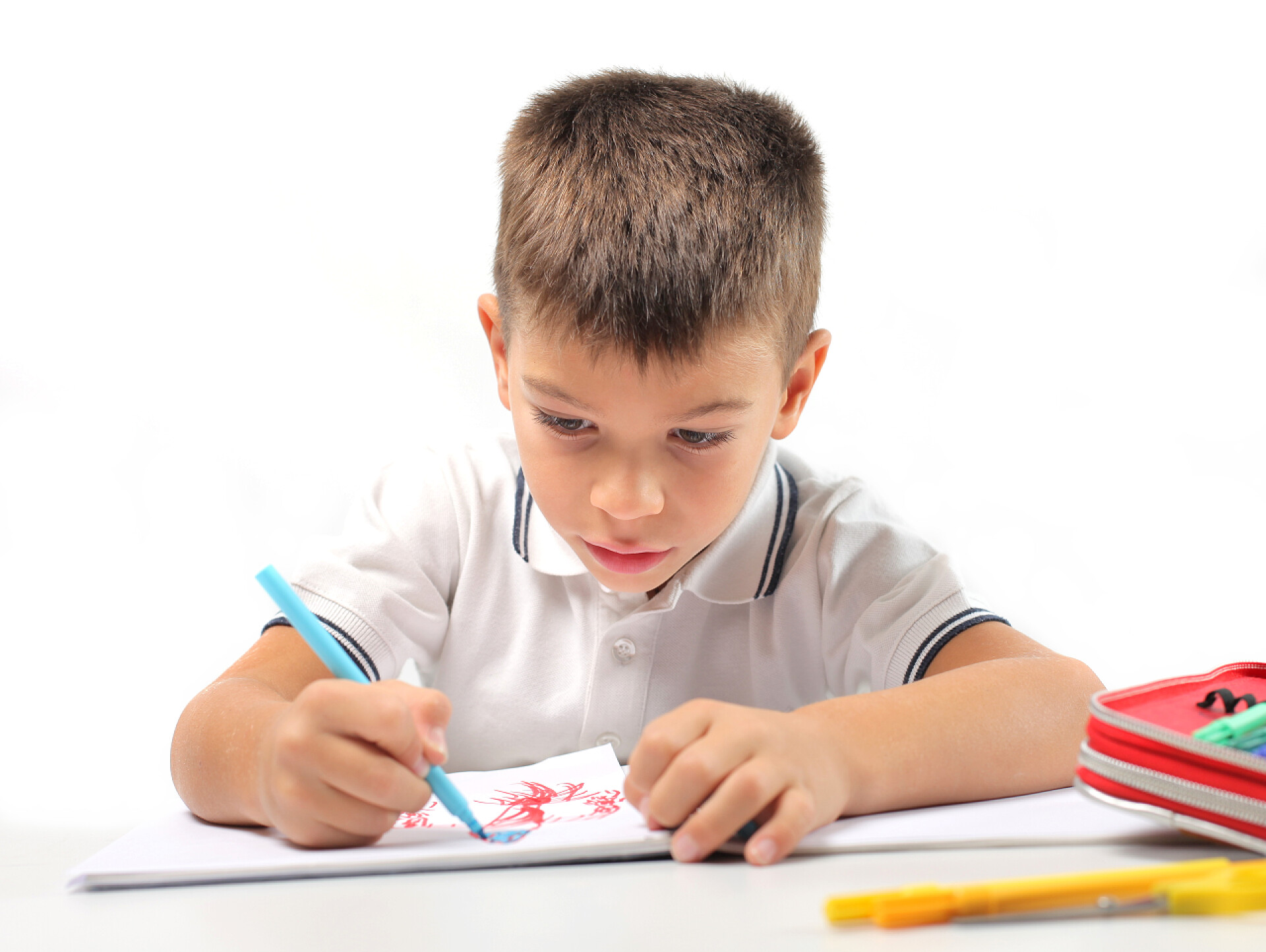 小男孩拿着彩笔在纸上画画油漆