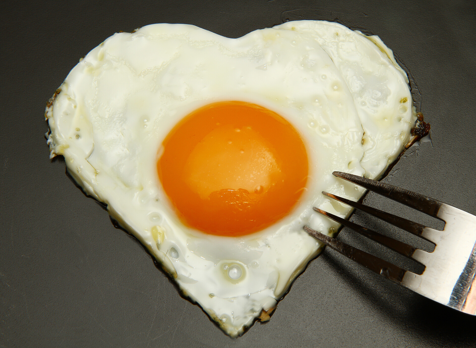 灰色背景上的爱心荷包蛋煎蛋