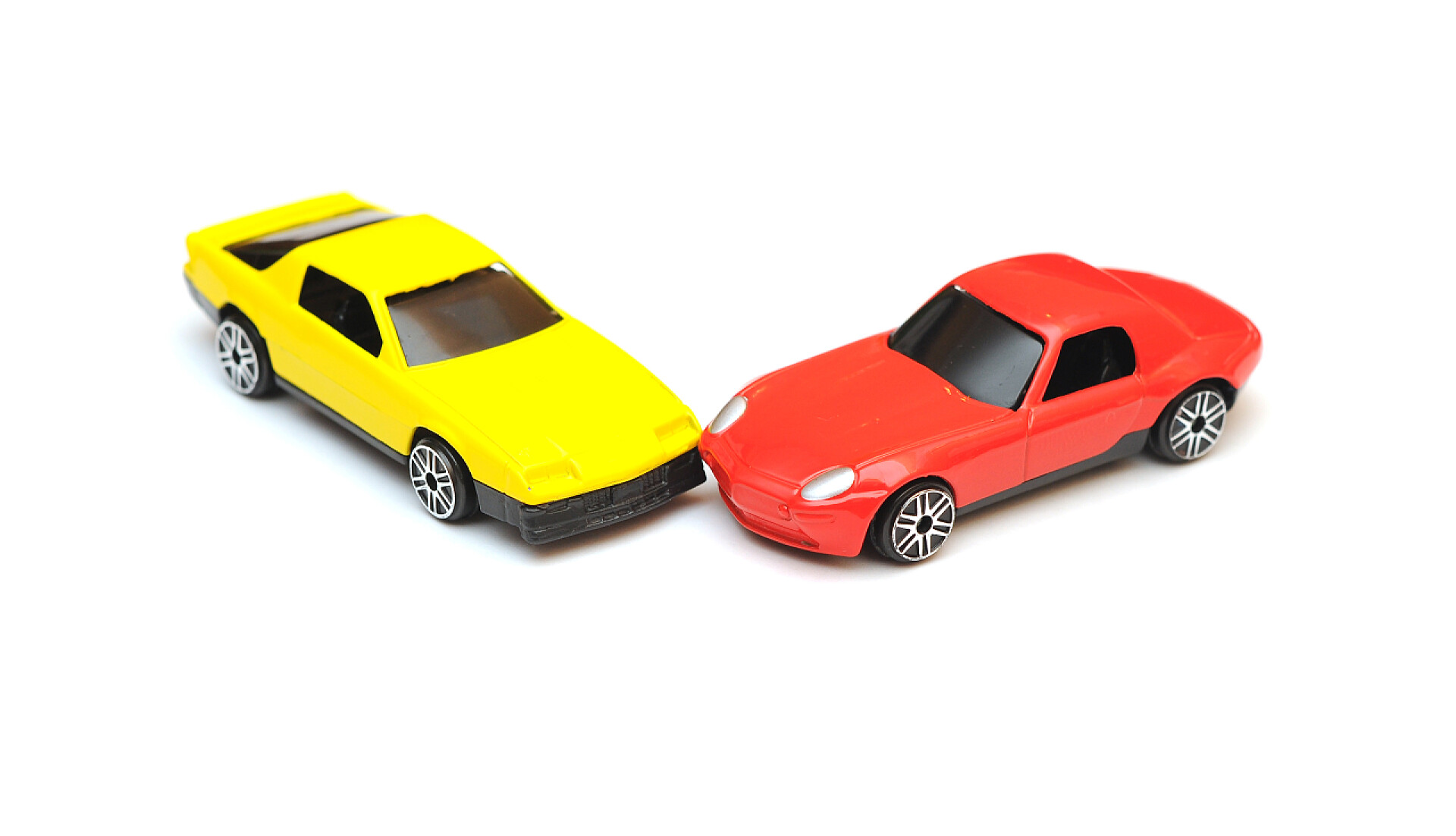 白色背景上两个玩具车相撞玩具车事故。汽车在白色上孤立的崩溃