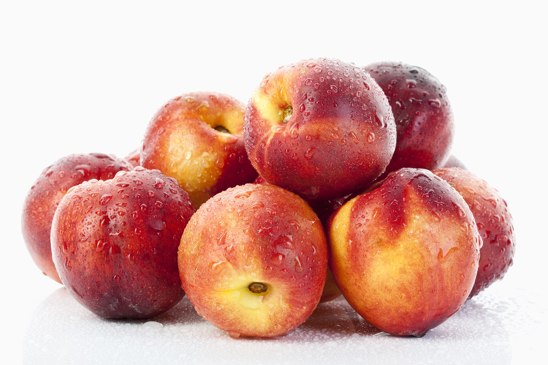 白色背景新鲜的红油桃堆积在一起桃子