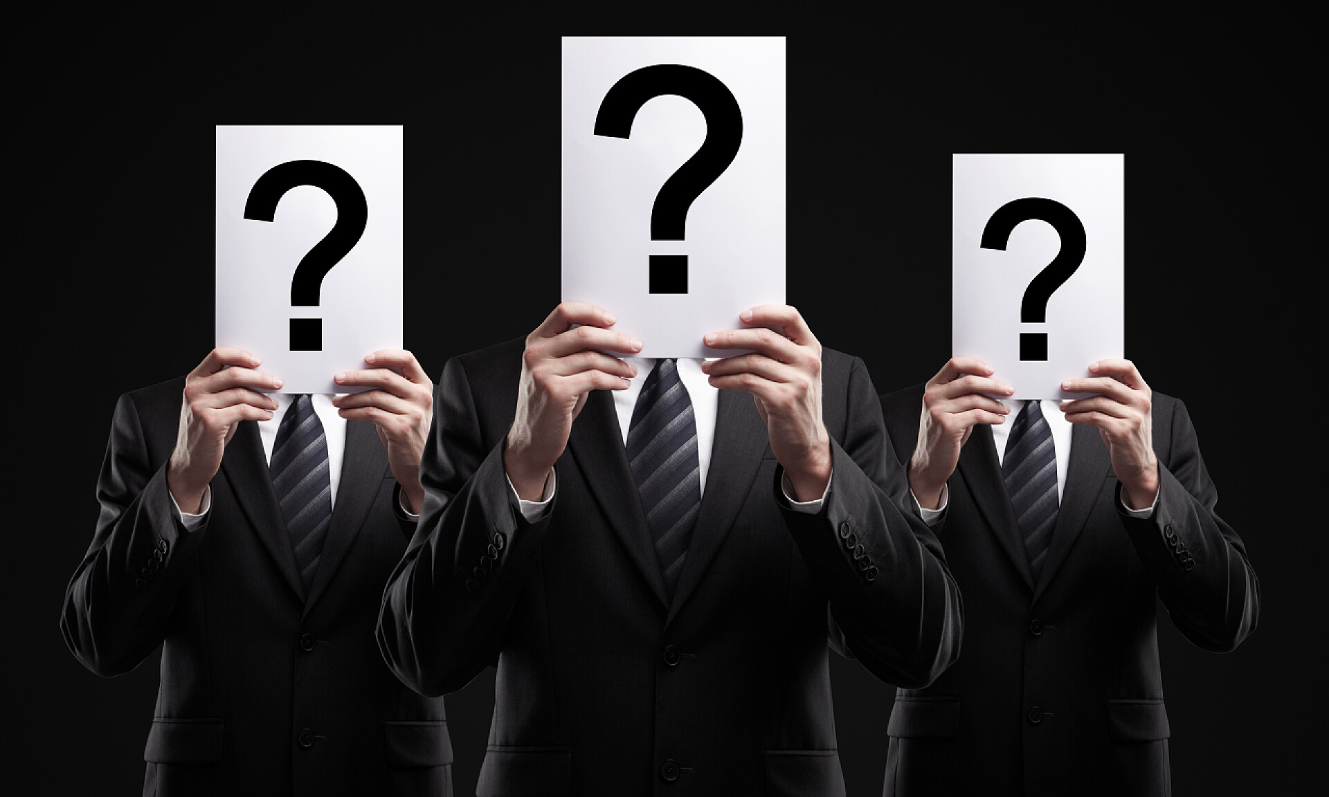 黑色背景上集团的业务员手持有一张纸上面写着问号集团的业务持有一个问号