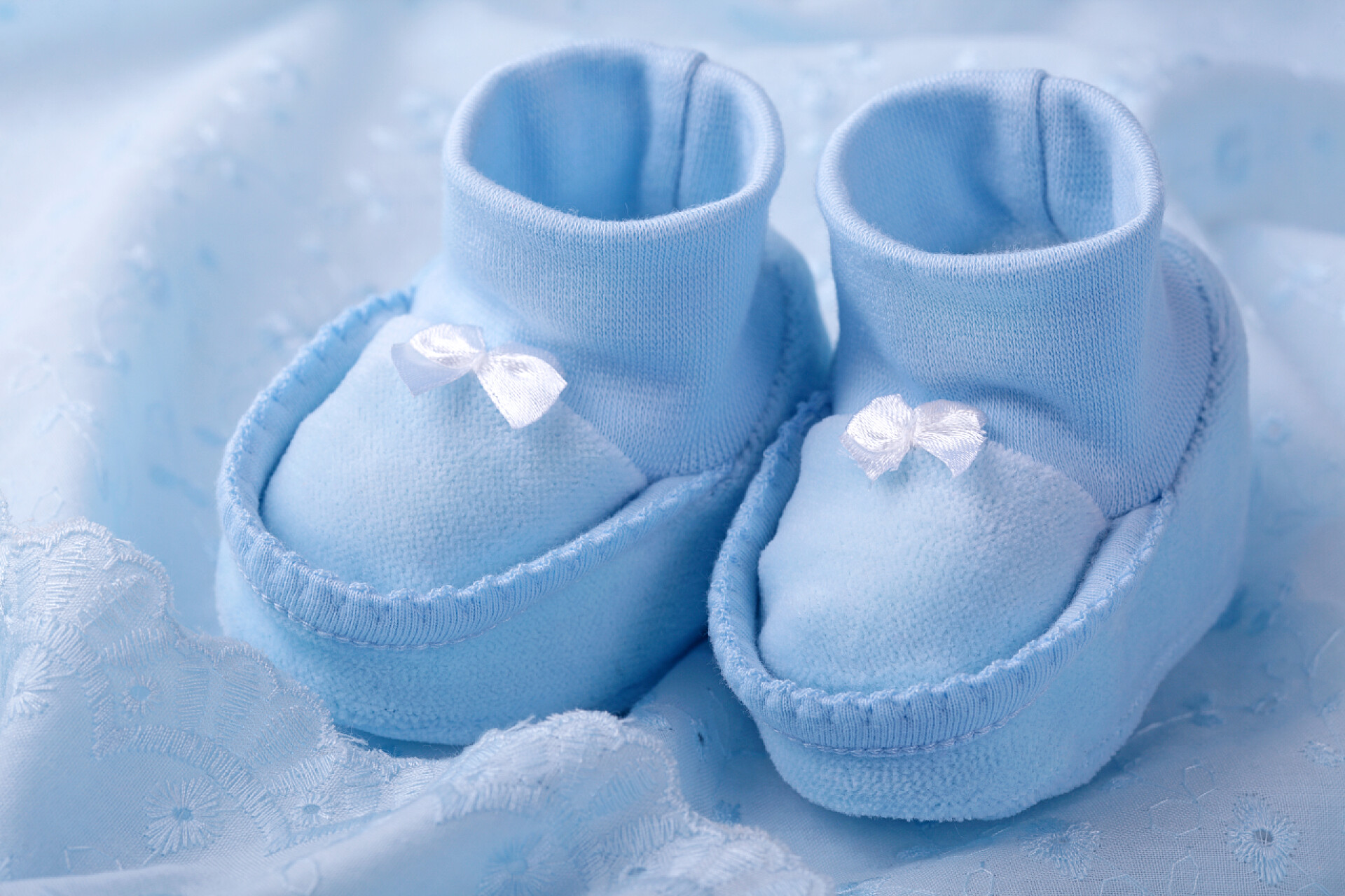 蓝色背景上的蓝色婴儿鞋蓝色婴儿袜