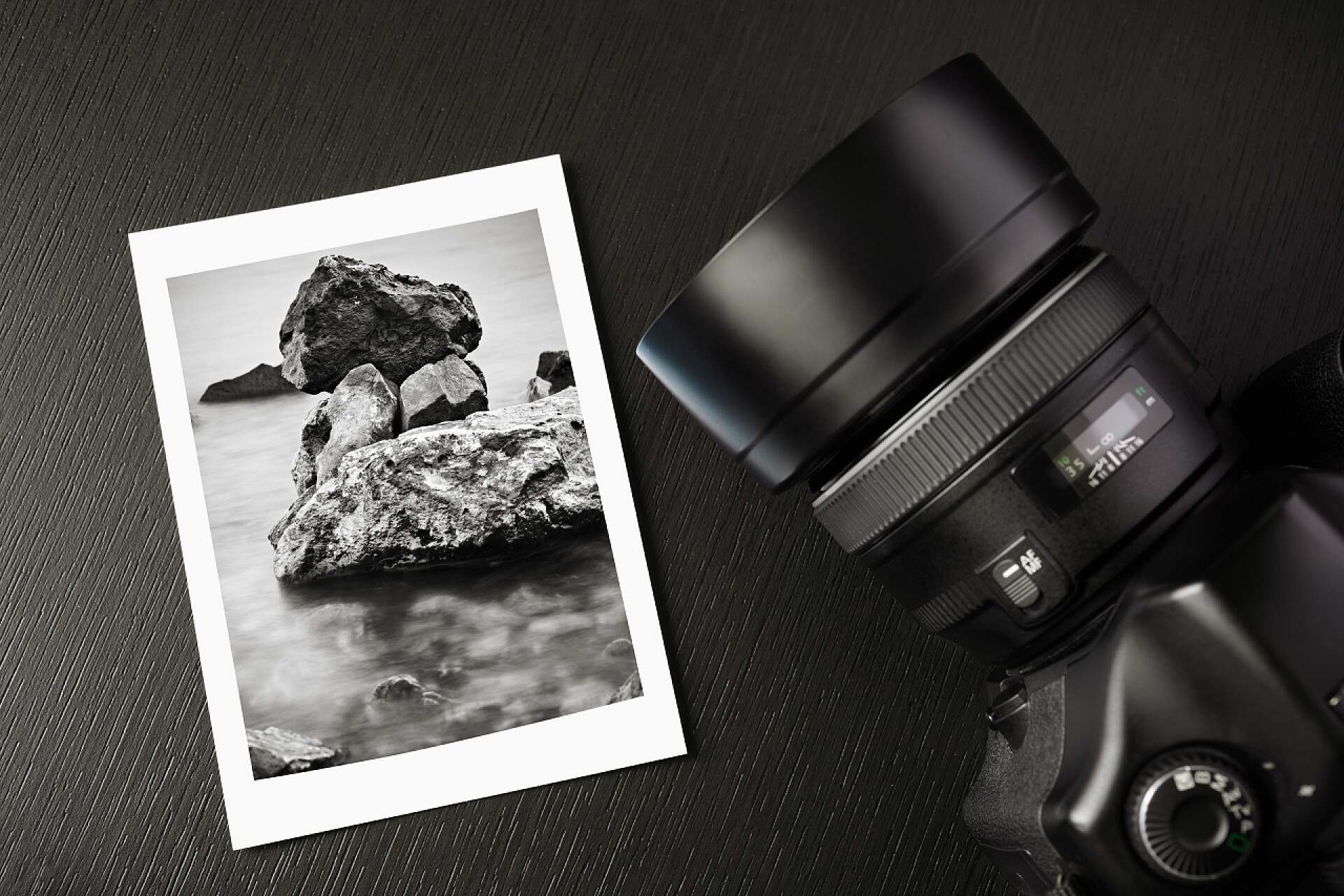 在黑色的桌子上有一台相机和一张黑白色照片摄影