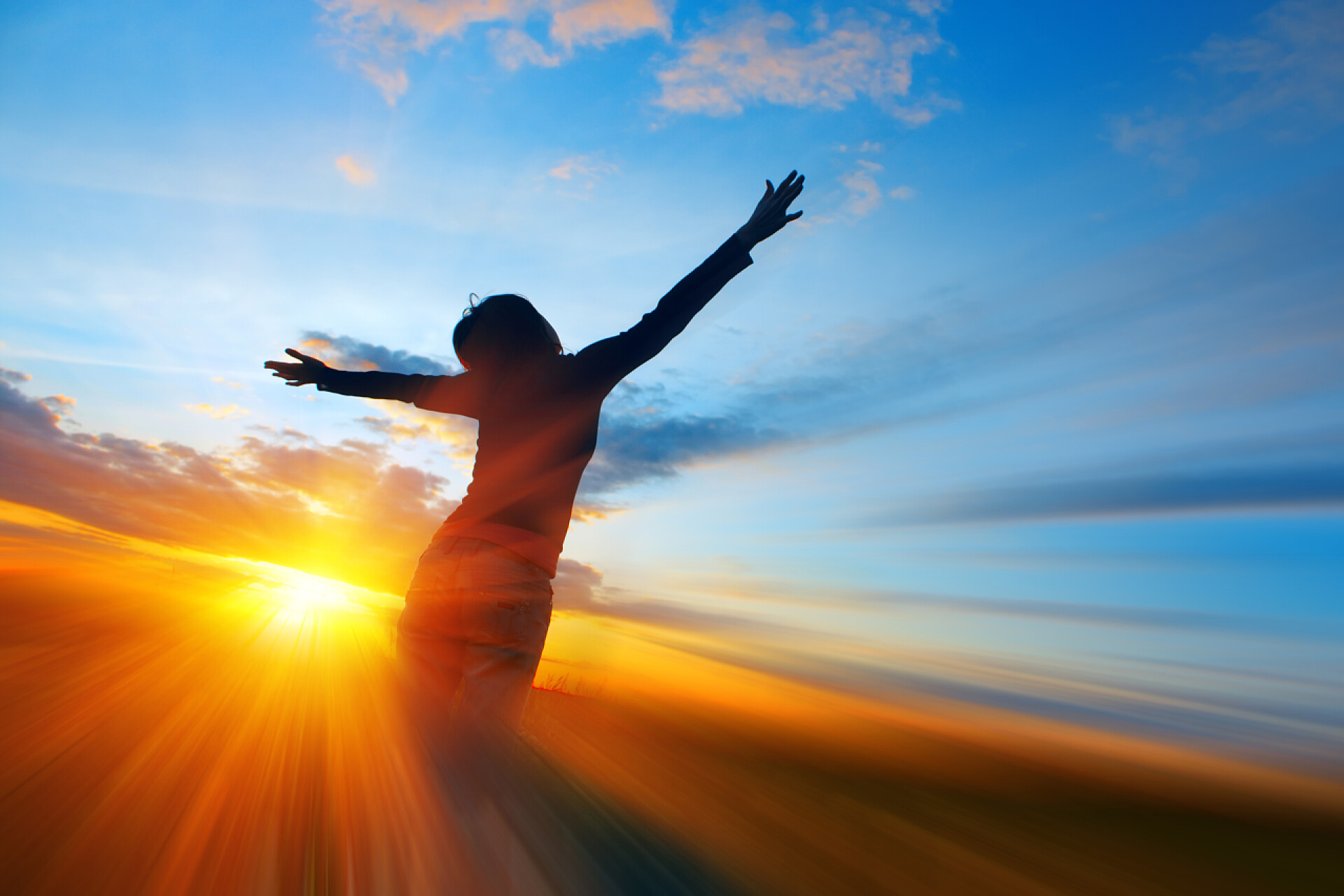 女孩张开双手拥抱夕阳的剪影女青年