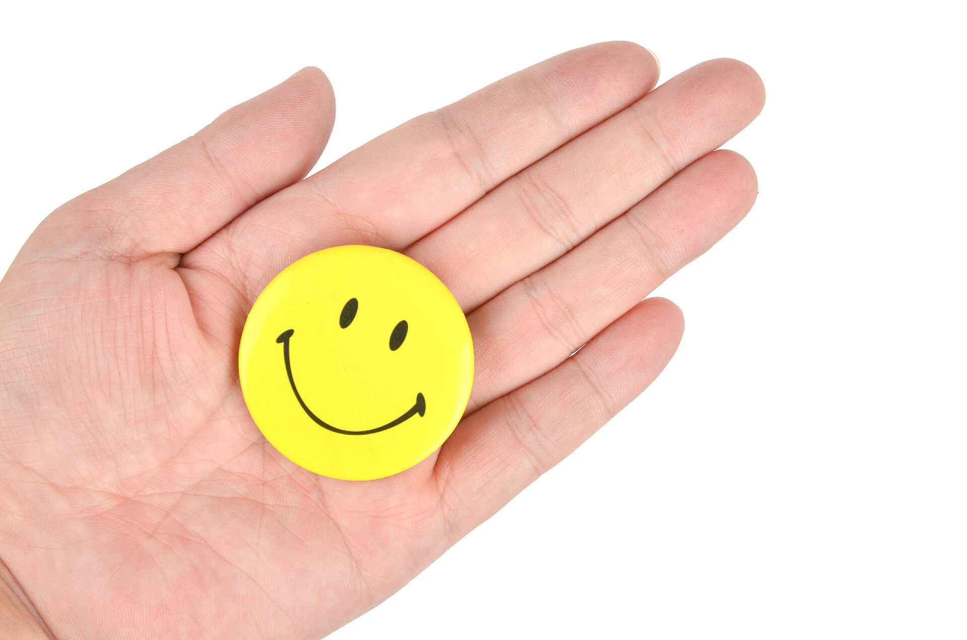 白色背景笑脸徽章放在手掌上微笑的脸