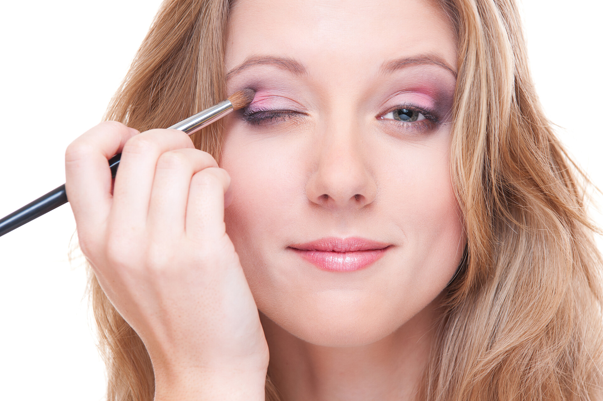 白色背景美丽的年轻女子在化妆工作室拍摄的美丽的年轻女子在做做