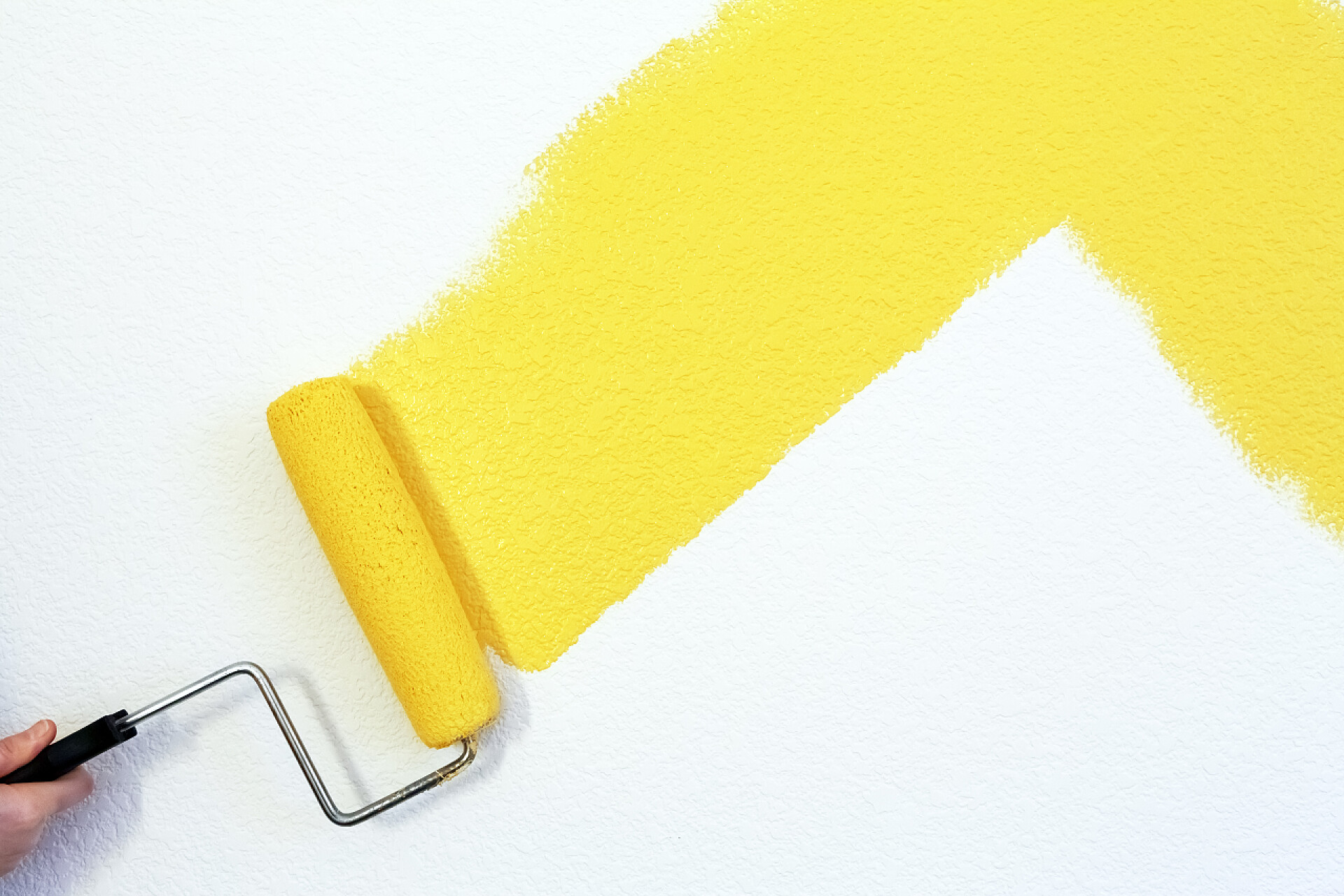 用滚筒给墙面图上黄色的油漆绘画