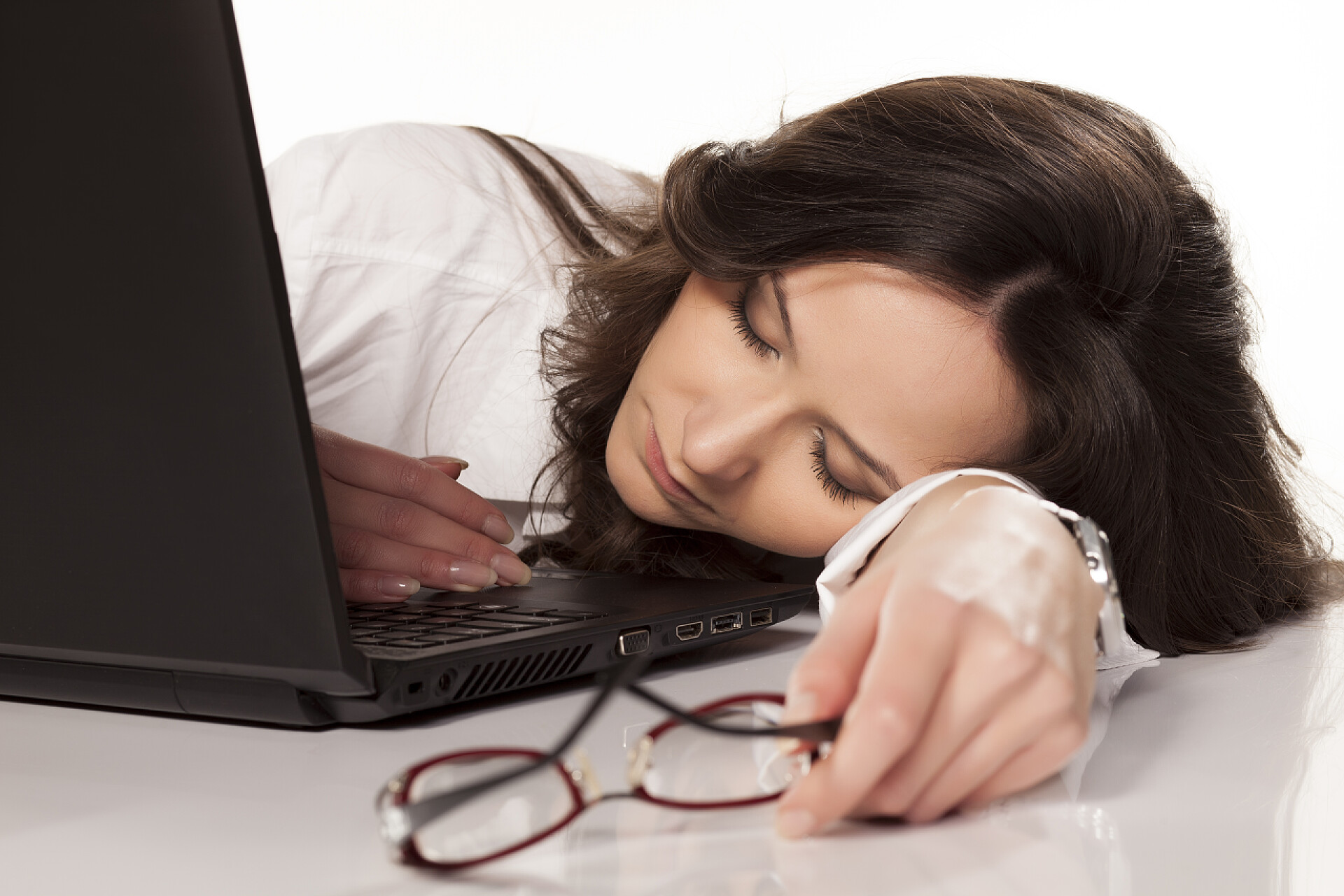 白色背景上在电脑前睡觉的女人累和无聊