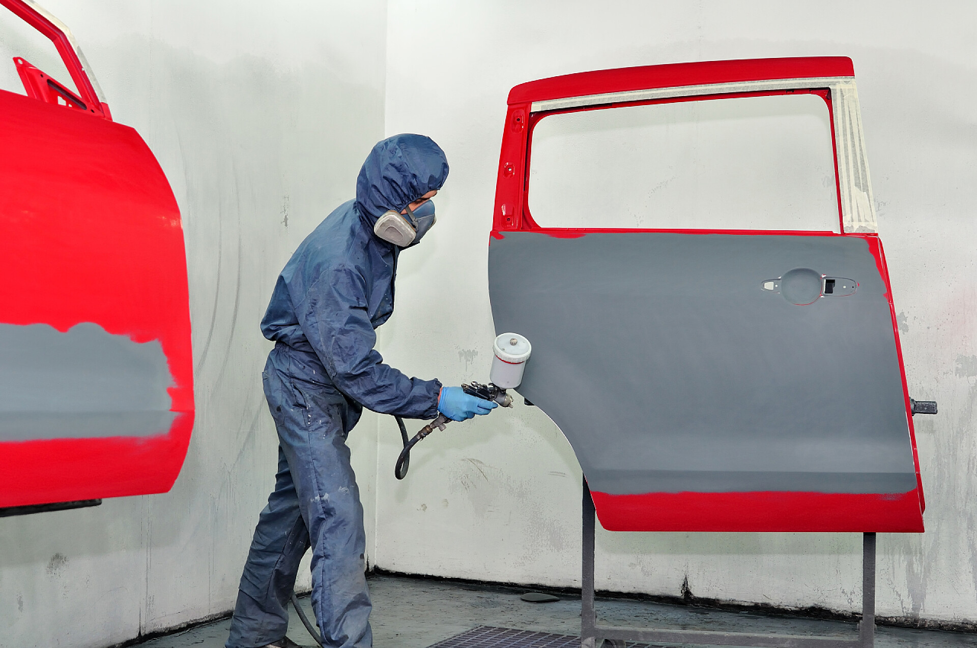 给汽车门喷灰色油漆的工人工人绘画开车门.