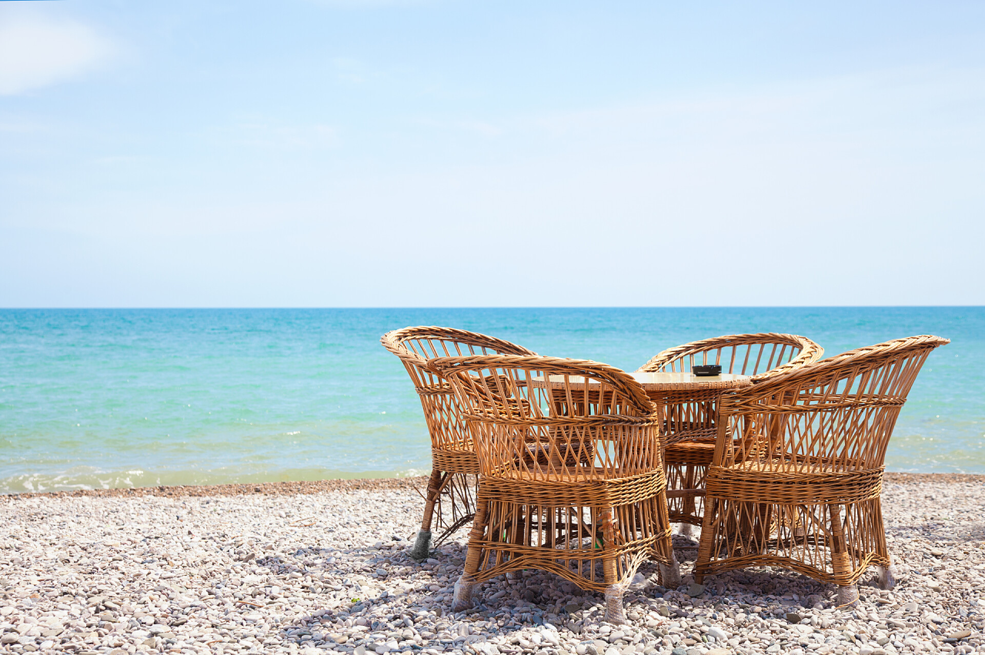 海滩上的藤条桌椅在海滩上的柳条椅子