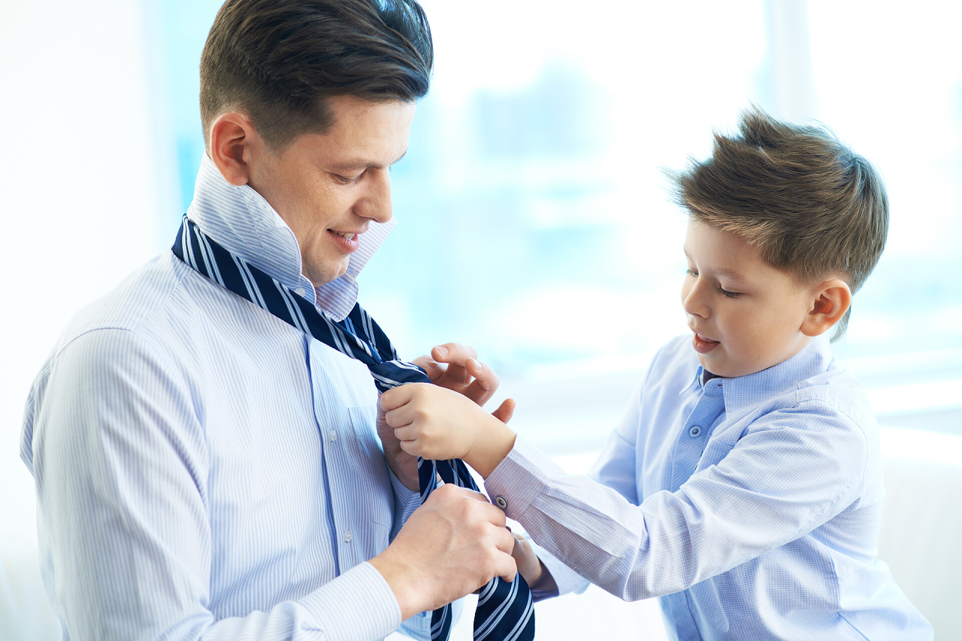 帮助父亲打领带领带的小男孩穿衣服