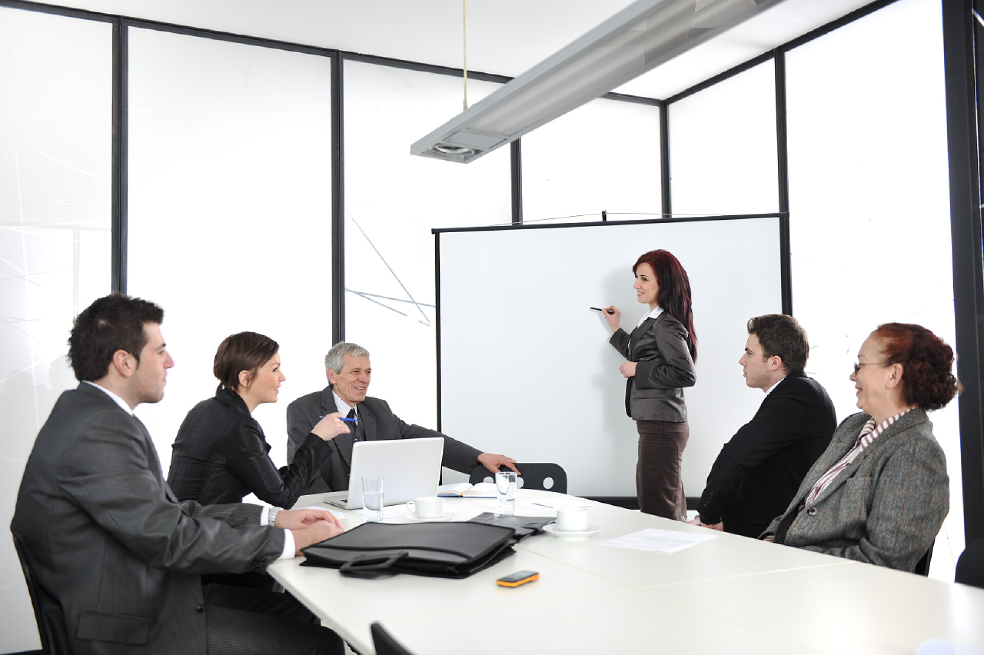 女商人在会议中演示文稿在演示文稿中绘制图的女商人