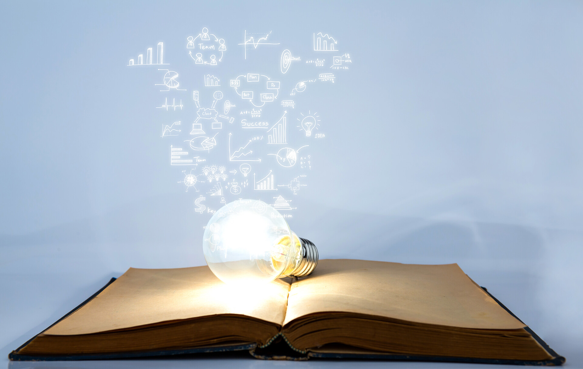 打开的书本放着一个亮光灯泡书和灯泡与业务图