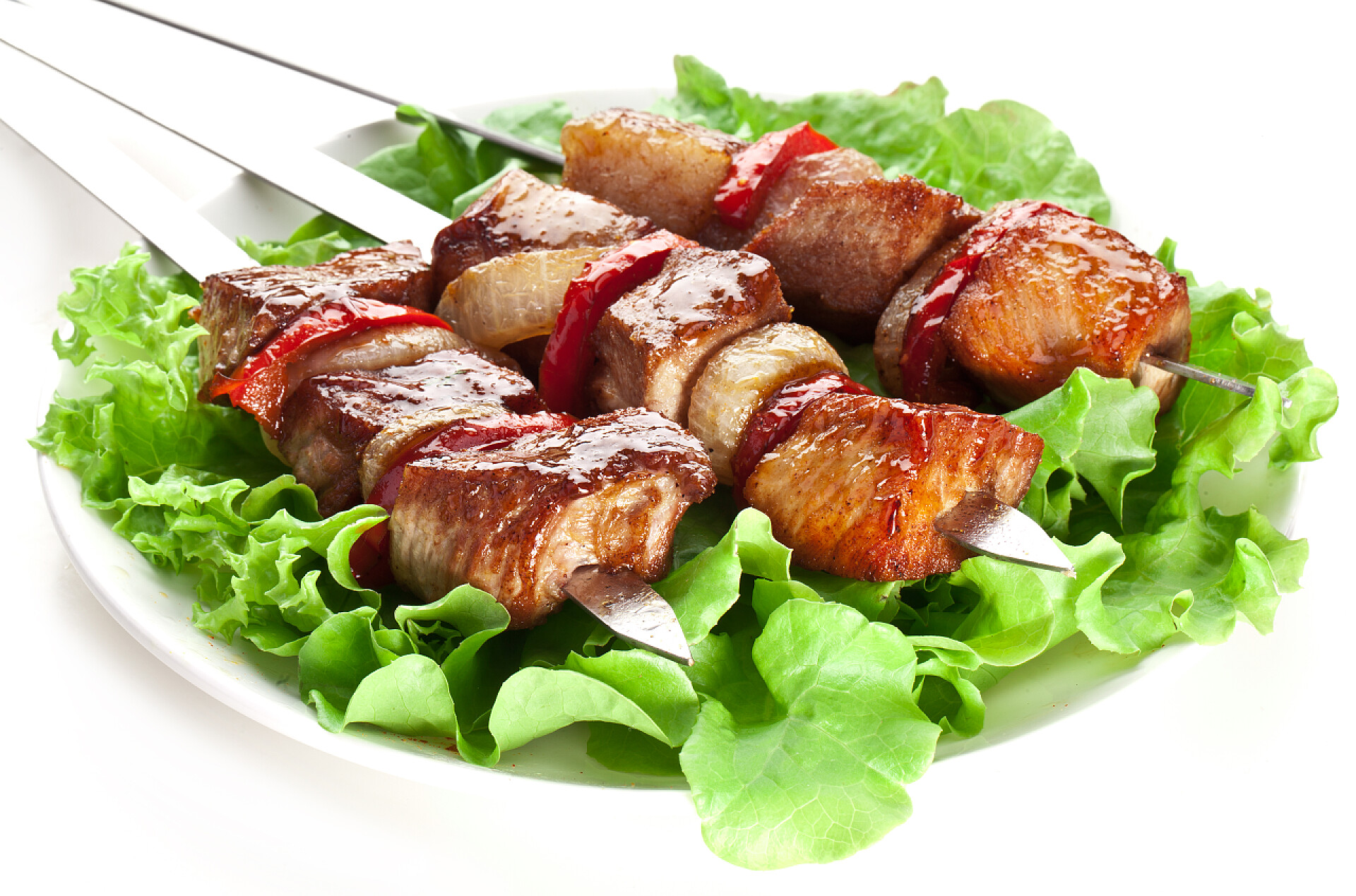 在白色背景上孤立的一盘猪肉烤串烤的烤肉 (串) 上吐一口唾沫.